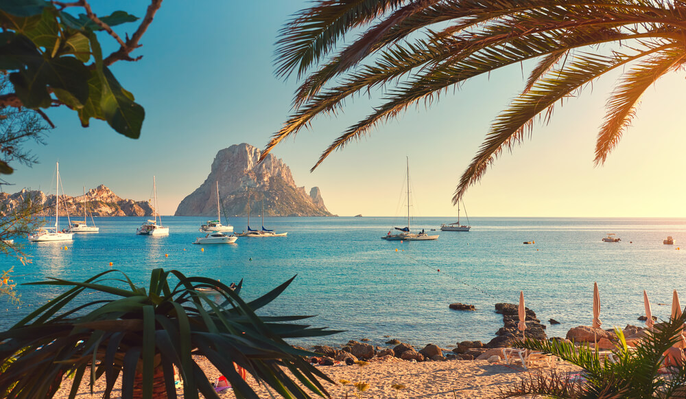 Spiaggia di Cala d'Hort, Ibiza: Vista su Es Vedra con navi nella baia.